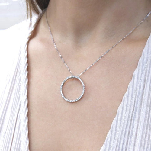Woman wearing white gold necklace with a diamond circle pendant